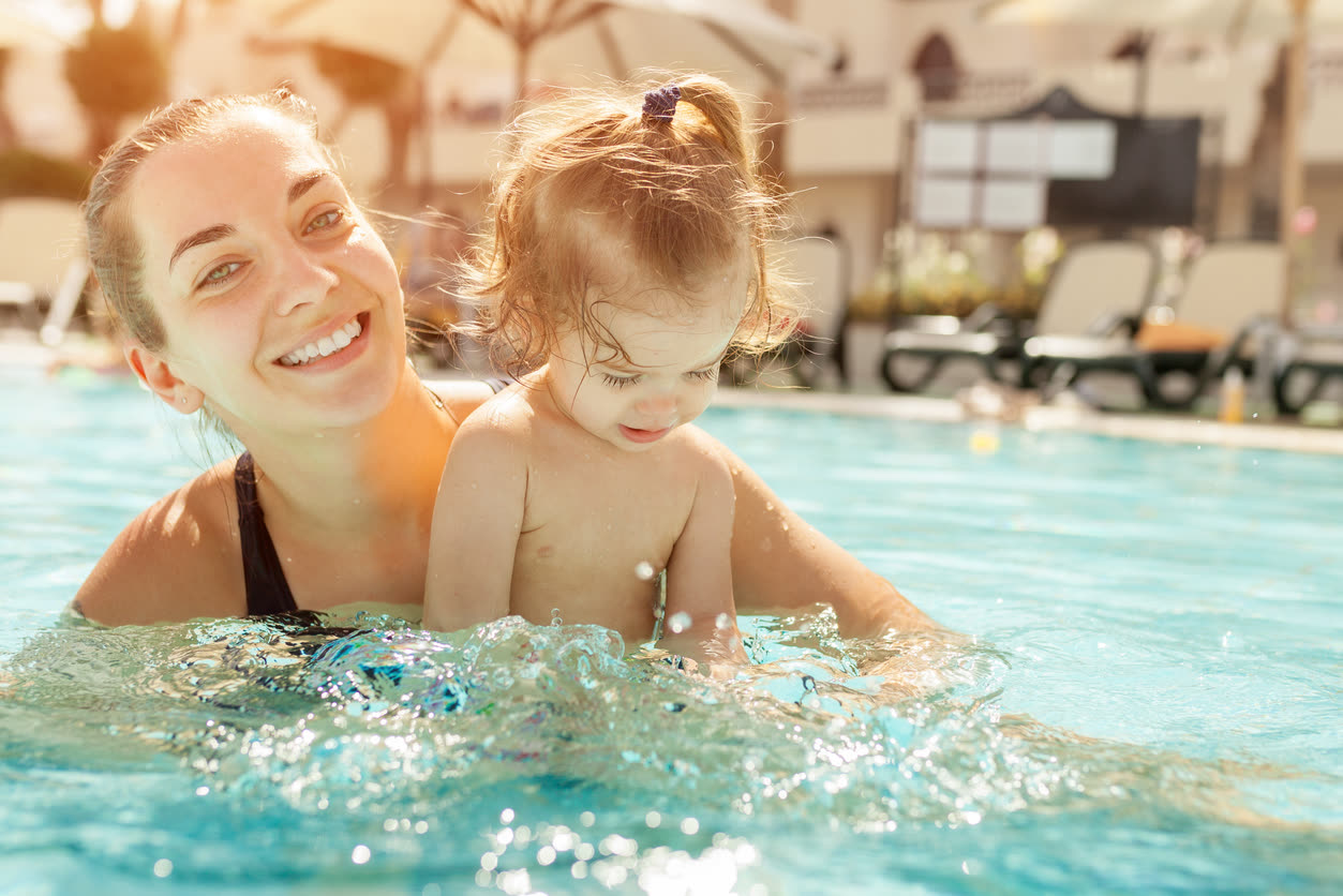 Mother and toddler playing in the hotel pool