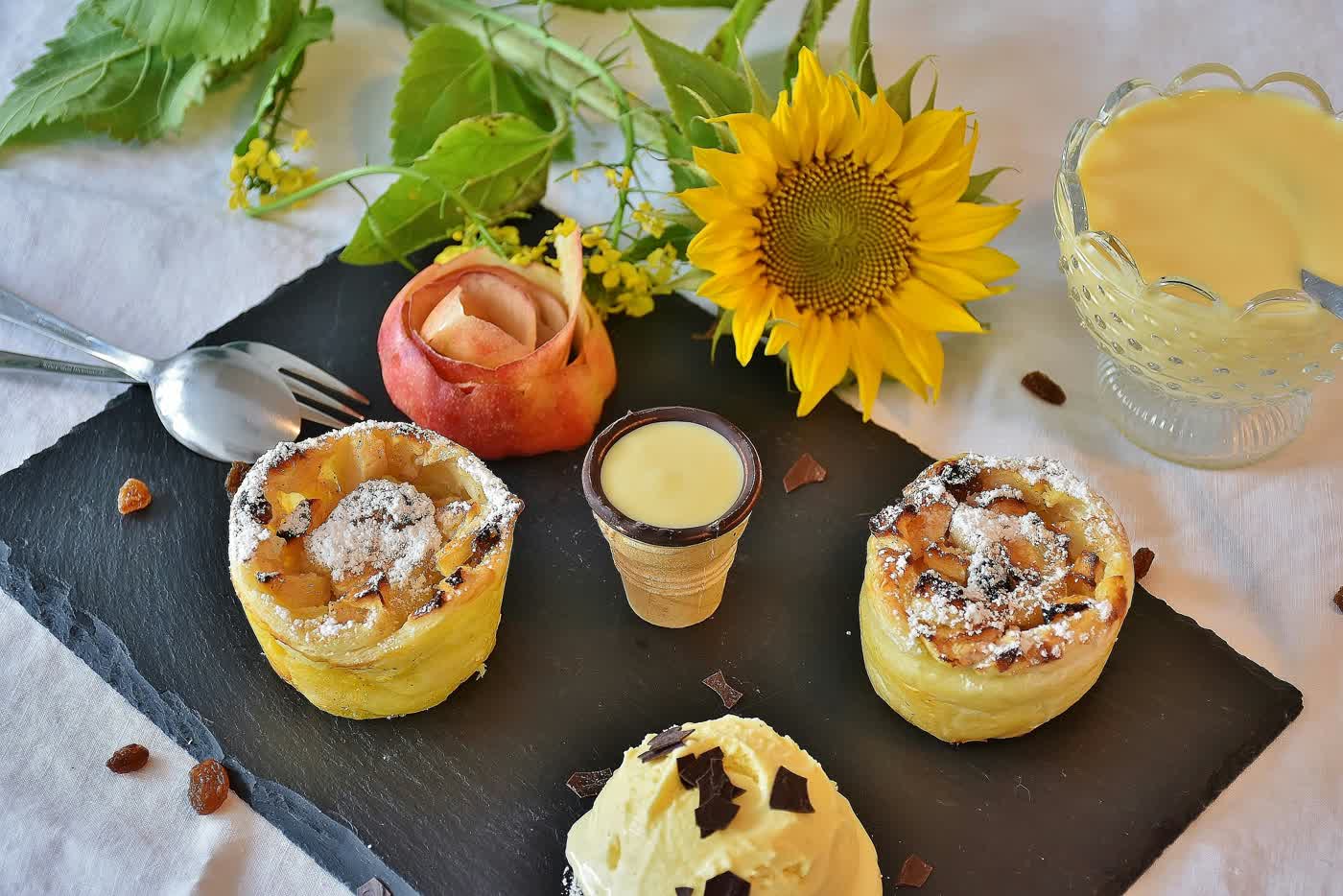 Apple pastries dusted with sugar, served with custard